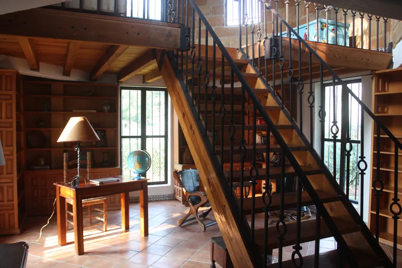 Estudio con escritorio y escalera de madera al tapanco