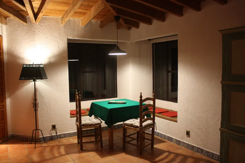 Mesa de juegos con paño verde junto a la ventana